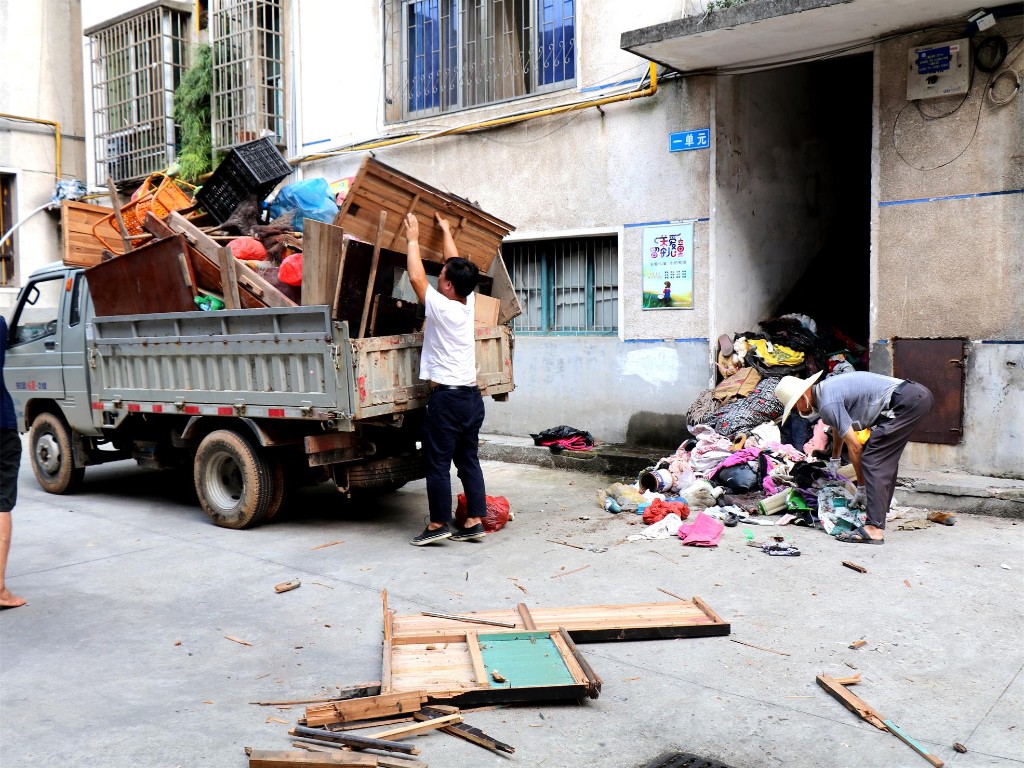 社区干部正在清理楼道的垃圾和杂物